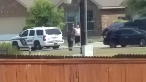 Cell phone video aired by KSAT shows Gilbert Flores standing outside of his San Antonio home Friday during a domestic violence call. In the video, Flores, 41, raises his hands over his head then suddenly collapses to the ground after he is apparently shot by deputies. Cell phone video aired by KSAT shows Gilbert Flores standing outside of his San Antonio home Friday during a domestic violence call. In the video, Flores, 41, raises his hands over his head then suddenly collapses to the ground after he is apparently shot by deputies. - Sputnik International