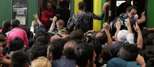 A young child cries as hundreds of migrants try to board a train at the Keleti Railway Station in Budapest, Hungary, Thursday, Sept. 3, 2015 A young child cries as hundreds of migrants try to board a train at the Keleti Railway Station in Budapest, Hungary, Thursday, Sept. 3, 2015 - Sputnik International