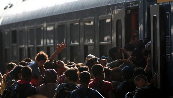 Migrants storm into a train at the Keleti train station in Budapest, Hungary, September 3, 2015 as Hungarian police withdrew from the gates after two days of blocking their entry Migrants storm into a train at the Keleti train station in Budapest, Hungary, September 3, 2015 as Hungarian police withdrew from the gates after two days of blocking their entry - Sputnik International