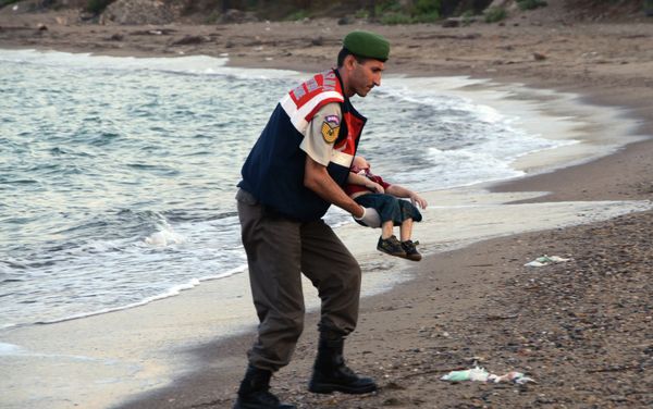 A paramilitary police officer carries the lifeless body of an unidentified migrant child, lifting it from the sea shore, near the Turkish resort of Bodrum, Turkey, early Wednesday, Sept. 2, 2015. - Sputnik International