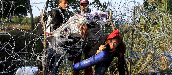 Syrian migrants cross under a fence as they enter Hungary at the border with Serbia, near Roszke, August 27, 2015 Syrian migrants cross under a fence as they enter Hungary at the border with Serbia, near Roszke, August 27, 2015 - Sputnik International
