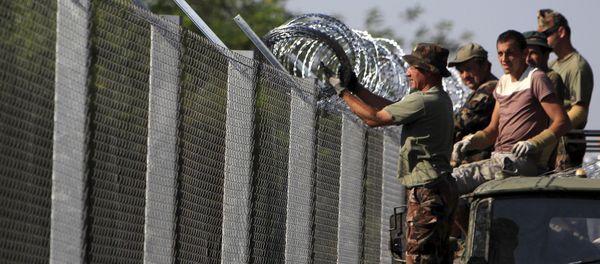 Hungarian soldiers adjust the razor wire on a fence near the town of Asotthalom, Hungary, August 30, 2015 Hungarian soldiers adjust the razor wire on a fence near the town of Asotthalom, Hungary, August 30, 2015 - Sputnik International