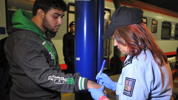 A Czech police officer writes a number on the skin of a refugee in Breclav, Czech Republic September 1, 2015 A Czech police officer writes a number on the skin of a refugee in Breclav, Czech Republic September 1, 2015 - Sputnik International