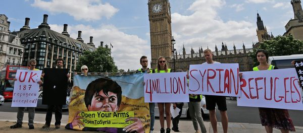Protestors hold banners during an Amnesty International protest in Parliament Square to urge the British government to do more to help Syrian refugees, London, Saturday, July 11, 2015. Protestors hold banners during an Amnesty International protest in Parliament Square to urge the British government to do more to help Syrian refugees, London, Saturday, July 11, 2015. - Sputnik International