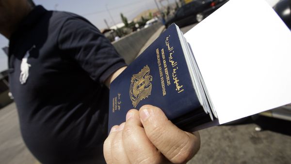 A Syrian man carries passports of relatives before getting them stamped on the Lebanese-Syrian border in al-Masnaa on July 20, 2012 - Sputnik International