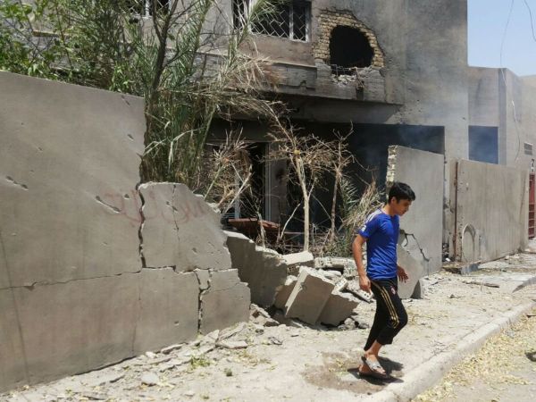 Abdullah Ahmed walks outside his home that was damaged in a bombing in Fallujah, Iraq. The U.S. and its coalition allies have carried out more than 1,000 strikes in Iraq since its campaign began in August - as well as hundreds more by American and Arab air forces in neighboring Syria.  - Sputnik International