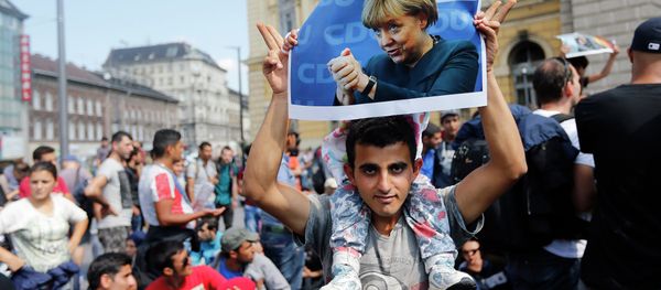 A man holds up a poster of German Chacellor Angela Merkel before starting a march out of Budapest, Hungary, Friday, Sept. 4, 2015 A man holds up a poster of German Chacellor Angela Merkel before starting a march out of Budapest, Hungary, Friday, Sept. 4, 2015 - Sputnik International