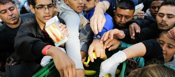 Migrants grab for food delivered by volunteers as they wait for registration at the reception center for refugees and asylum seekers in Berlin, Germany, Friday, Sept. 4, 2015 Migrants grab for food delivered by volunteers as they wait for registration at the reception center for refugees and asylum seekers in Berlin, Germany, Friday, Sept. 4, 2015 - Sputnik International