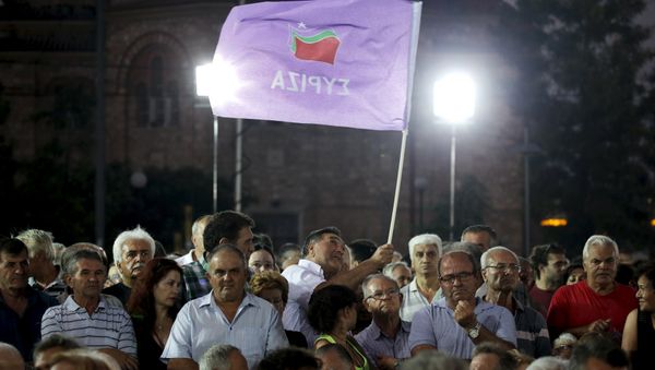 A leftist Syriza party supporter waves a party flag during a speech of former Greek Prime Minister and leader of the party Alexis Tsipras (not pictured) at a pre-election rally in the western suburb of Egaleo, in Athens, Greece, in this September 3, 2015 file photo A leftist Syriza party supporter waves a party flag during a speech of former Greek Prime Minister and leader of the party Alexis Tsipras (not pictured) at a pre-election rally in the western suburb of Egaleo, in Athens, Greece, in this September 3, 2015 file photo - Sputnik International