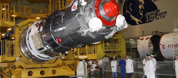 Specialists of RSC Energia work to install the payload shroud on a manned Soyuz TMA-02M spacecraft in the assembly and test complex at Baikonur Cosmodrome, where work proceeds on building a Soyuz-FG space rocket - Sputnik International