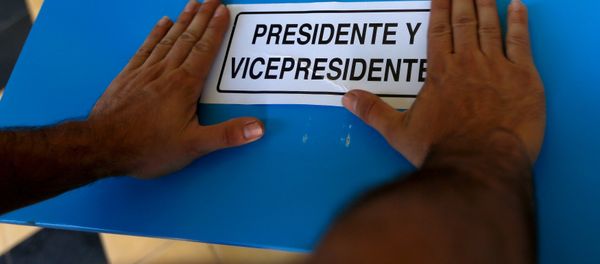 A electoral worker places a sign to mark the ballot box for President and Vice-President while installing a polling station at a school in Guatemala City, September 5, 2015 - Sputnik International