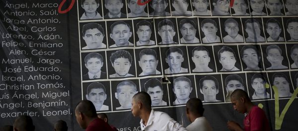 Newly enrolled students stand near a banner showing the photographs of the 43 missing students of the Ayotzinapa teachers' training college, at the college in Tixtla, on the outskirts oft Chilpancingo, in the Mexican state of Guerrero, August 16, 2015 Newly enrolled students stand near a banner showing the photographs of the 43 missing students of the Ayotzinapa teachers' training college, at the college in Tixtla, on the outskirts oft Chilpancingo, in the Mexican state of Guerrero, August 16, 2015 - Sputnik International