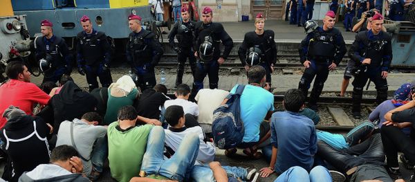 Riot police stand on the train track as they monitor migrants and refugees at the Keleti (eastern) railway station in Budapest on September 1, 2015 - Sputnik International