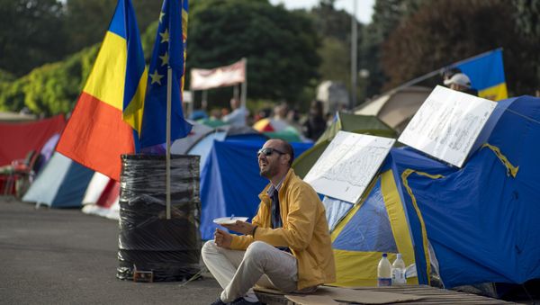 A demonstrator has breakfast as he sits next to tents set up by protesters in central Chisinau on September 7, 2015 after an anti-government rally. - Sputnik International