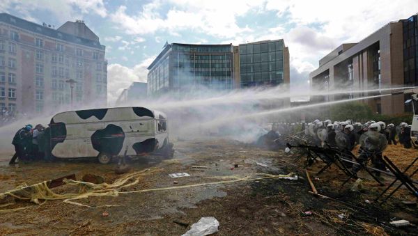Protesters shelter behind a caravan as Belgian riot police uses water canons - Sputnik International