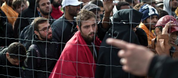 Migrants waiting in line to board buses in Hungary - Sputnik International