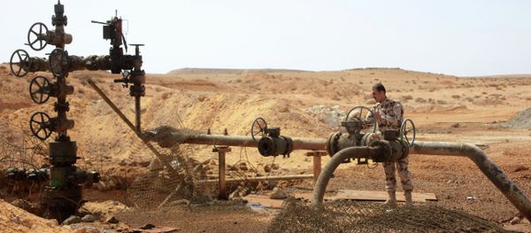 A member of the Syrian government forces stands next to a well at Jazel oil field, near the ancient city of Palmyra in the east of Homs province. A member of the Syrian government forces stands next to a well at Jazel oil field, near the ancient city of Palmyra in the east of Homs province. - Sputnik International
