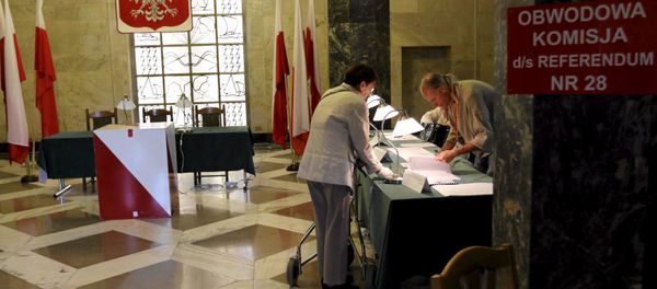 A woman takes her ballot paper during a referendum asking people to vote on changing the voting system, the funding of political parties and taxation rules, in Warsaw, Poland, September 6, 2015. A woman takes her ballot paper during a referendum asking people to vote on changing the voting system, the funding of political parties and taxation rules, in Warsaw, Poland, September 6, 2015. - Sputnik International