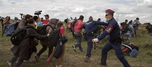 Hungarian police officers stop migrants as they try to escape on a field nearby a collection point in the village of Roszke, Hungary, September 8, 2015. Hungarian police officers stop migrants as they try to escape on a field nearby a collection point in the village of Roszke, Hungary, September 8, 2015. - Sputnik International