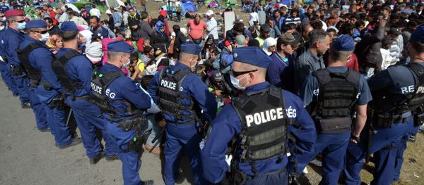 Migrants are controlled by police officers at a refugee collection point near the Hungarian-Serbian border of Roszke village on September 7, 2015 Migrants are controlled by police officers at a refugee collection point near the Hungarian-Serbian border of Roszke village on September 7, 2015 - Sputnik International
