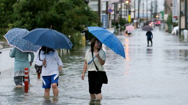 Pedestrians wade through flood waters on a road following torrential rains brought on by Typhoon Etau in Hamamatsu, Shizuoka prefecture, central Japan on September 8, 2015 - Sputnik International