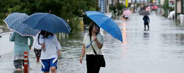 Pedestrians wade through flood waters on a road following torrential rains brought on by Typhoon Etau in Hamamatsu, Shizuoka prefecture, central Japan on September 8, 2015 - Sputnik International
