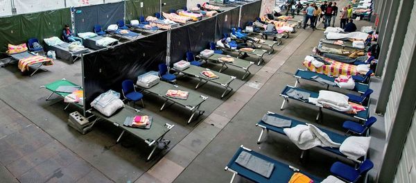 Refugees and migrants arrive in their accommodation, the exhibition halls of the Trade Fair Messe Erfurt, in Erfurt, central Germany, Tuesday, Sept. 8, 2015. The city of Erfurt expect up to 600 migrants to arrive within some hours. - Sputnik International