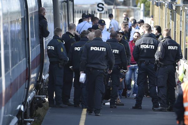 Danish police guard a train carrying migrants, mainly from Syria and Iraq, at Rodby train station, south of Denmark, September 9, 2015. The migrants, hoping to get to Sweden, arrived at Rodby on Tuesday night and refused to leave the train to get registered in Denmark.  - Sputnik International