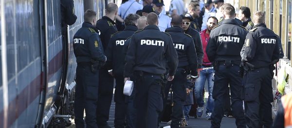 Danish police guard a train carrying migrants, mainly from Syria and Iraq, at Rodby train station, south of Denmark, September 9, 2015. The migrants, hoping to get to Sweden, arrived at Rodby on Tuesday night and refused to leave the train to get registered in Denmark. Danish police guard a train carrying migrants, mainly from Syria and Iraq, at Rodby train station, south of Denmark, September 9, 2015. The migrants, hoping to get to Sweden, arrived at Rodby on Tuesday night and refused to leave the train to get registered in Denmark. - Sputnik International