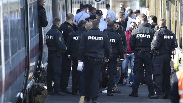 Danish police guard a train carrying migrants, mainly from Syria and Iraq, at Rodby train station, south of Denmark, September 9, 2015. The migrants, hoping to get to Sweden, arrived at Rodby on Tuesday night and refused to leave the train to get registered in Denmark. Danish police guard a train carrying migrants, mainly from Syria and Iraq, at Rodby train station, south of Denmark, September 9, 2015. The migrants, hoping to get to Sweden, arrived at Rodby on Tuesday night and refused to leave the train to get registered in Denmark. - Sputnik International