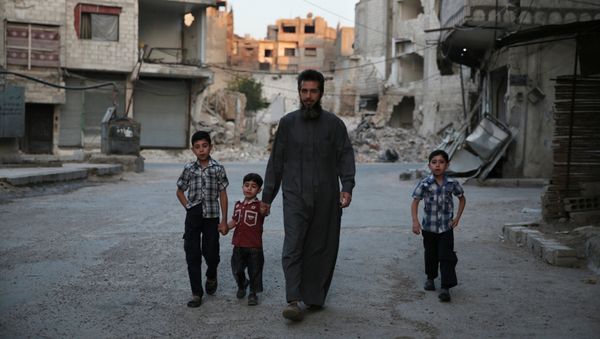 A Syrian man heads to a mosque with children in the rebel-held area of Douma, east of the capital Damascus A Syrian man heads to a mosque with children in the rebel-held area of Douma, east of the capital Damascus - Sputnik International