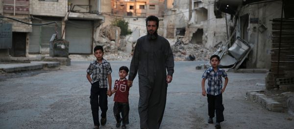 A Syrian man heads to a mosque with children in the rebel-held area of Douma, east of the capital Damascus A Syrian man heads to a mosque with children in the rebel-held area of Douma, east of the capital Damascus - Sputnik International