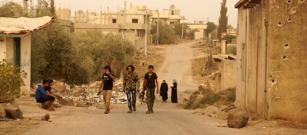 Free Syrian Army fighters walk with their weapons in the Deraa countryside September 9, 2015 Free Syrian Army fighters walk with their weapons in the Deraa countryside September 9, 2015 - Sputnik International