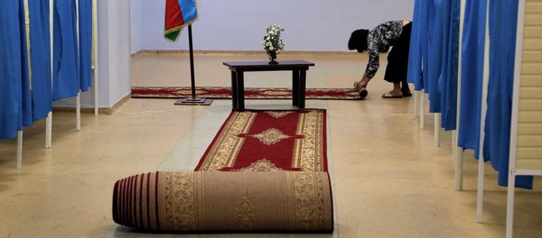 A worker rolls up the carpet between the voting booths at a polling station in Baku, Azerbaijan, Wednesday, Oct. 9, 2013 A worker rolls up the carpet between the voting booths at a polling station in Baku, Azerbaijan, Wednesday, Oct. 9, 2013 - Sputnik International