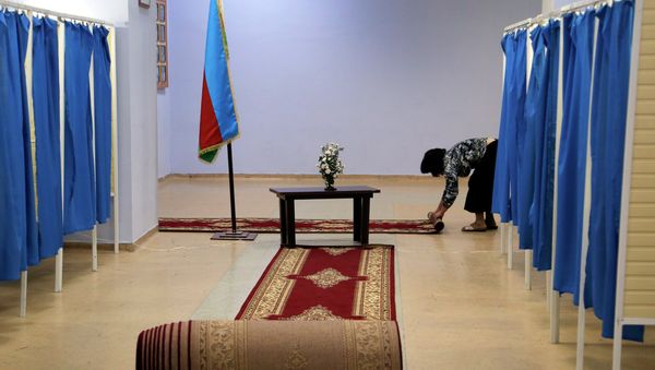 A worker rolls up the carpet between the voting booths at a polling station in Baku, Azerbaijan, Wednesday, Oct. 9, 2013 A worker rolls up the carpet between the voting booths at a polling station in Baku, Azerbaijan, Wednesday, Oct. 9, 2013 - Sputnik International