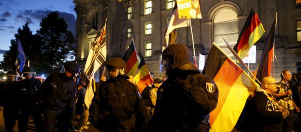 German police officers escort members of BAERGIDA, Berlin's section of anti-immigration movement Patriotic Europeans Against the Islamisation of the West (PEGIDA), during a rally as they walk next to the Reichstags building in Berlin, Germany September 7, 2015 - Sputnik International