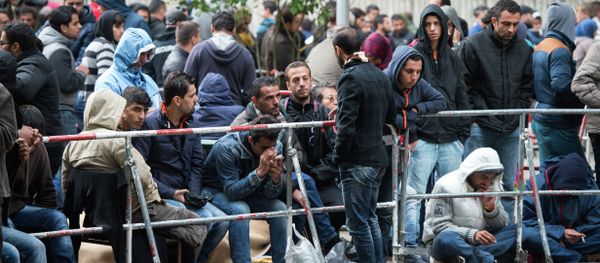 Refugees and migrants wait outside the Berlin State Office for Health and Social Affairs in Berlin, Germany, Friday Sept. 11, 2015 - Sputnik International
