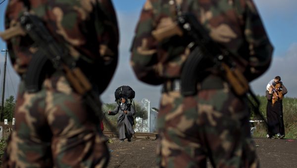 (File) Hungarian army officers stand at the Serbian-Hungarian border as a Syrian refugee women crosses, near Roszke, southern Hungary, Saturday, Sept. 12, 2015 - Sputnik International