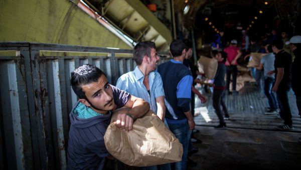 Unloading Russian plane with humanitarian aid which arrived to Latakia Airport in Syria. File photo Unloading Russian plane with humanitarian aid which arrived to Latakia Airport in Syria. File photo - Sputnik International