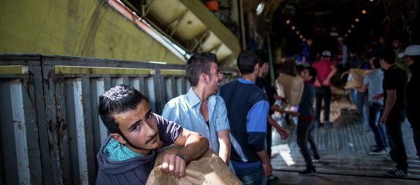 Unloading Russian plane with humanitarian aid which arrived to Latakia Airport in Syria. File photo Unloading Russian plane with humanitarian aid which arrived to Latakia Airport in Syria. File photo - Sputnik International
