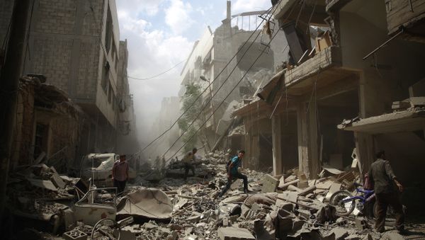 Syrians walk amid the rubble of destroyed buildings following reported air strikes by regime forces in the rebel-held area of Douma, east of the capital Damascus, on August 30, 2015 Syrians walk amid the rubble of destroyed buildings following reported air strikes by regime forces in the rebel-held area of Douma, east of the capital Damascus, on August 30, 2015 - Sputnik International