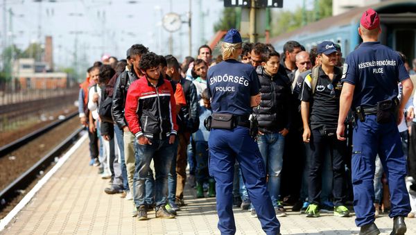Hungarian police officers stand guard as migrants disembark from a train at the railway station in the town of Hegyeshalom next to the Austrian Hungarian border, Hungary September 13, 2015 Hungarian police officers stand guard as migrants disembark from a train at the railway station in the town of Hegyeshalom next to the Austrian Hungarian border, Hungary September 13, 2015 - Sputnik International