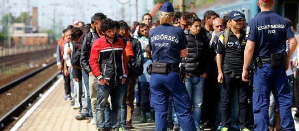 Hungarian police officers stand guard as migrants disembark from a train at the railway station in the town of Hegyeshalom next to the Austrian Hungarian border, Hungary September 13, 2015 - Sputnik International