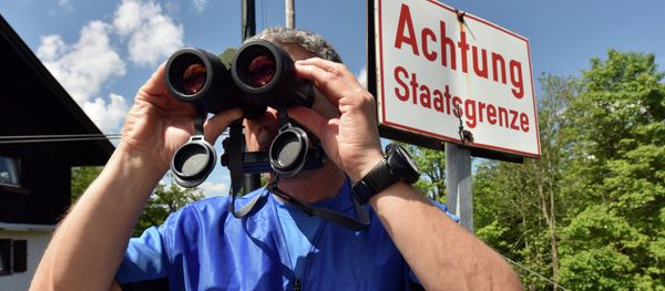 A policeman uses binoculars to secure the area on the Ederkanzel viewing platform near Mittenwald at the German-Austrian border on June 3, 2015 - Sputnik International