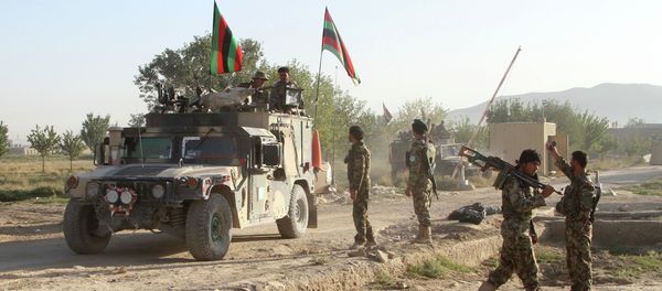 Afghan national army stand guard near the dead body of a Taliban attacker in front of the main prison building after an attack in Ghazni province, eastern Afghanistan, Monday, Sept. 14, 2015 - Sputnik International