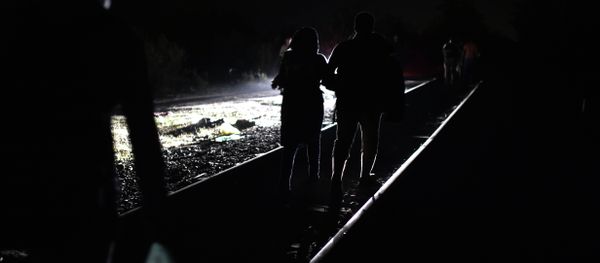 Syrian refugees and migrants cross the Serbian-Hungarian border as they walk on a railway line on September 1, 2015 - Sputnik International