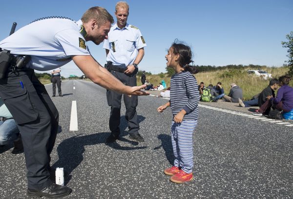 Danish policeman plays with a migrant girl at the E45 freeway north of Padborg September 9, 2015 - Sputnik International