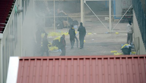 Migrants escape from smoke after a temporary detention center was set on fire, on the Italian island of Lampedusa, on April 11, 2011 - Sputnik International