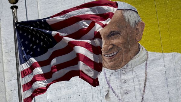 The US flag flies in front of a mural of Pope Francis on the side of a building in midtown Manhattan in New York August 28, 2015 - Sputnik International