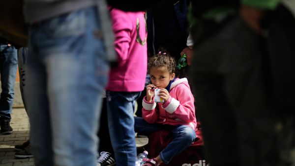 A girl drinks some juice after she arrived with other refugees at the train station of the southern German border town Passau, Tuesday, Sept. 15, 2015. - Sputnik International